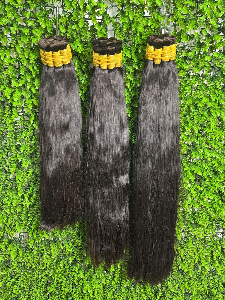 Três mechas de mega hair preto natural penduradas em ganchos, lisas e brilhantes